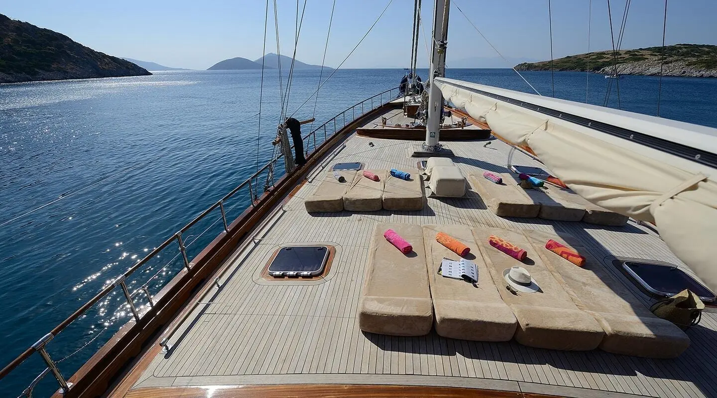 Zephyria II yacht deck with sun loungers overlooking calm sea at sunset