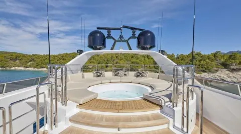Daloli yacht stern deck with jacuzzi and seating on aft platform, sunny day