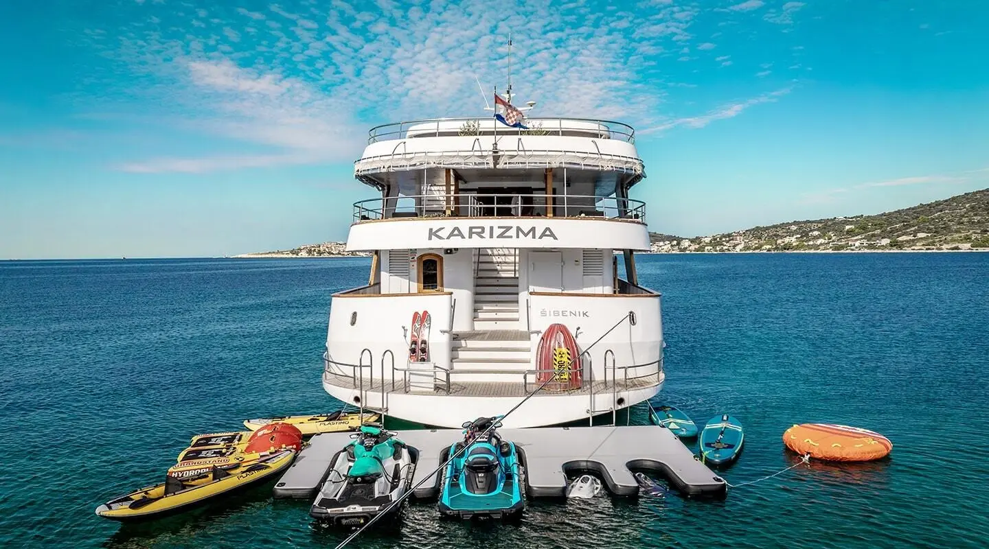 Karizma yacht anchored in clear blue water with lifesaving equipment on stern