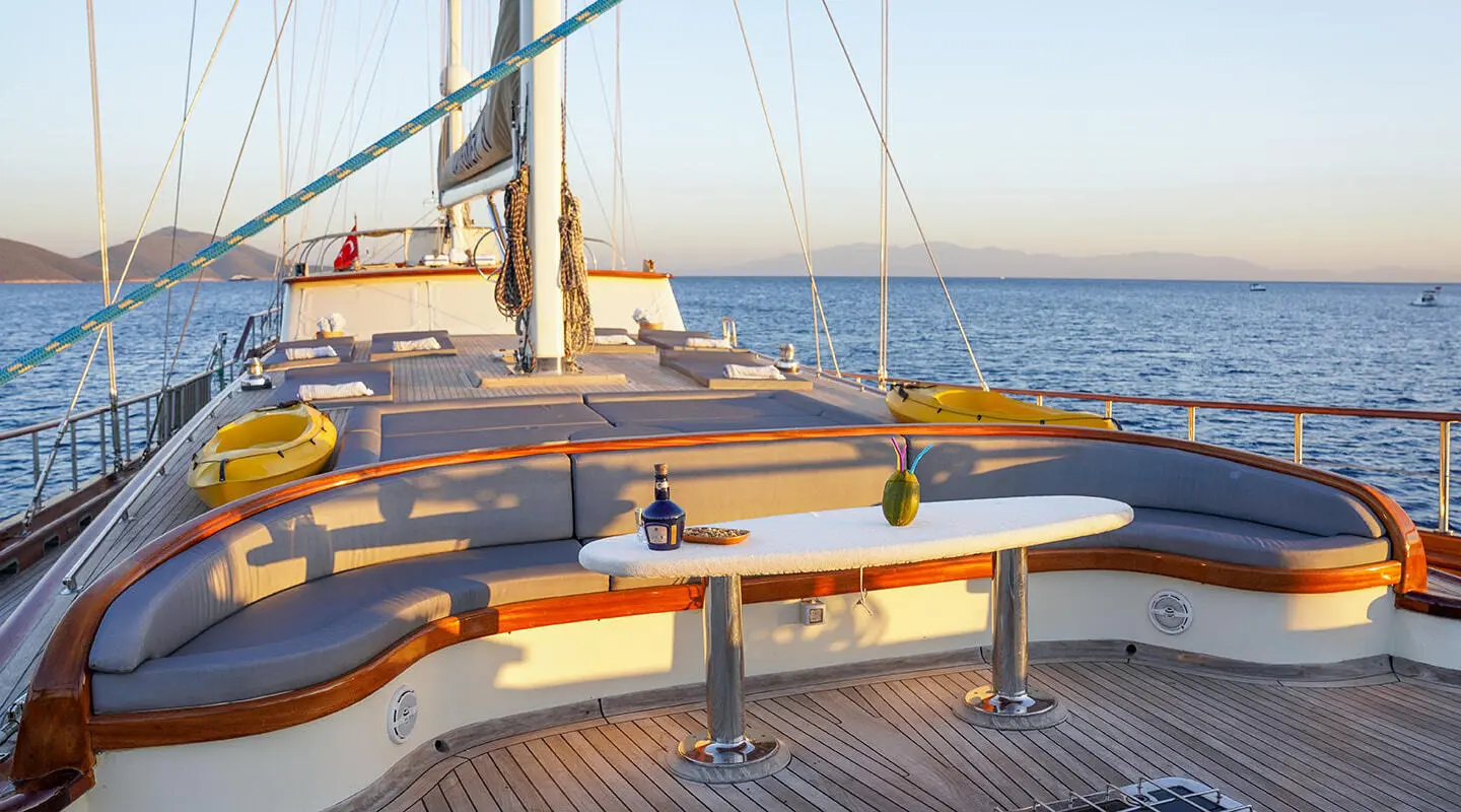 Deck with curved seating and table, sea view at sunset