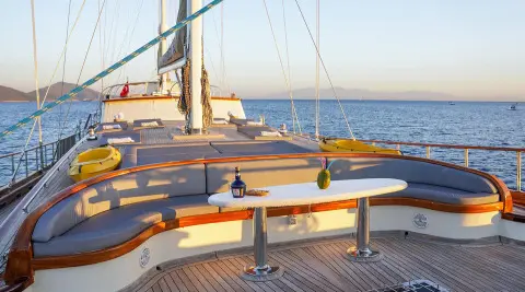 Deck with curved seating and table, sea view at sunset