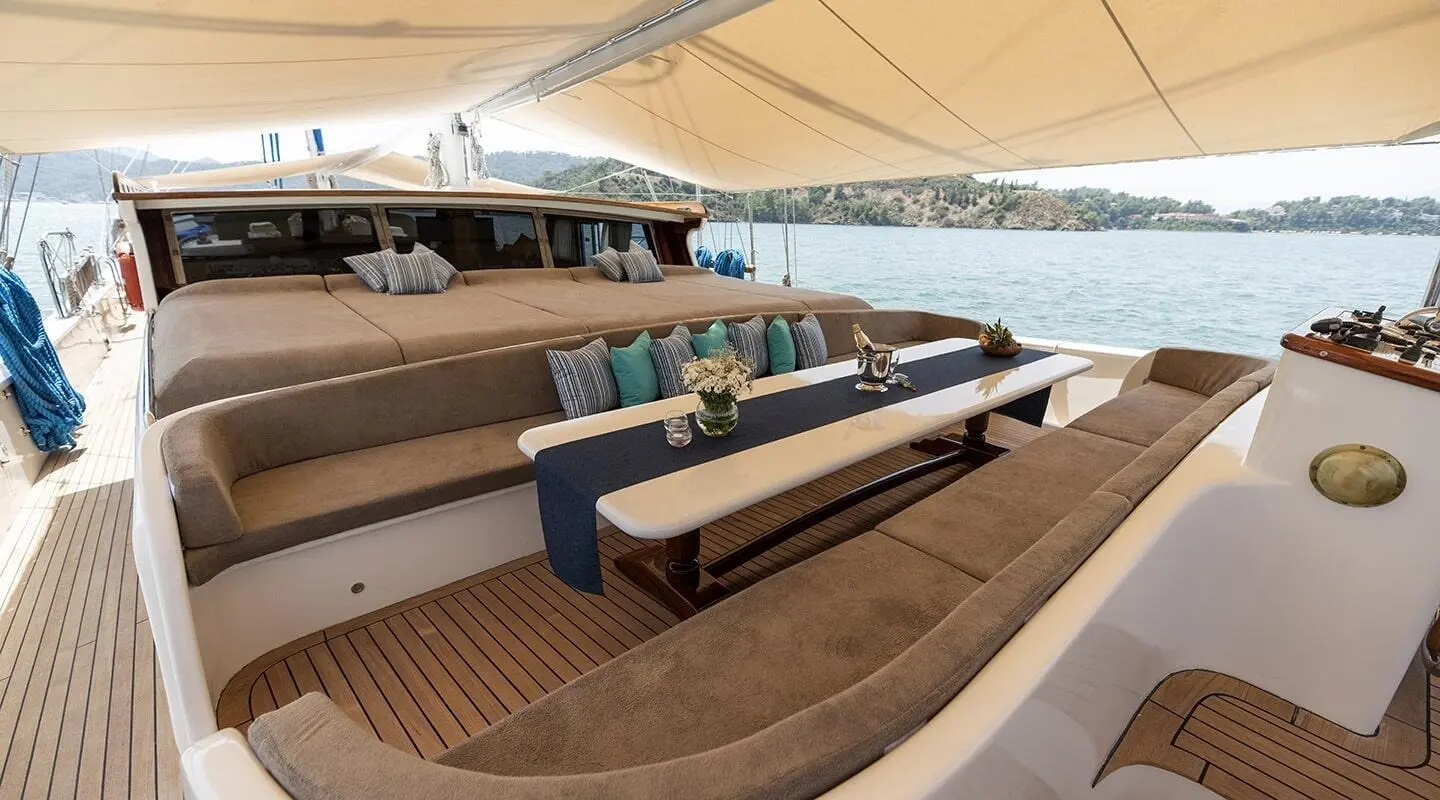 Kayhan Kaptan yacht gulet lounge area with wooden benches under shade sails