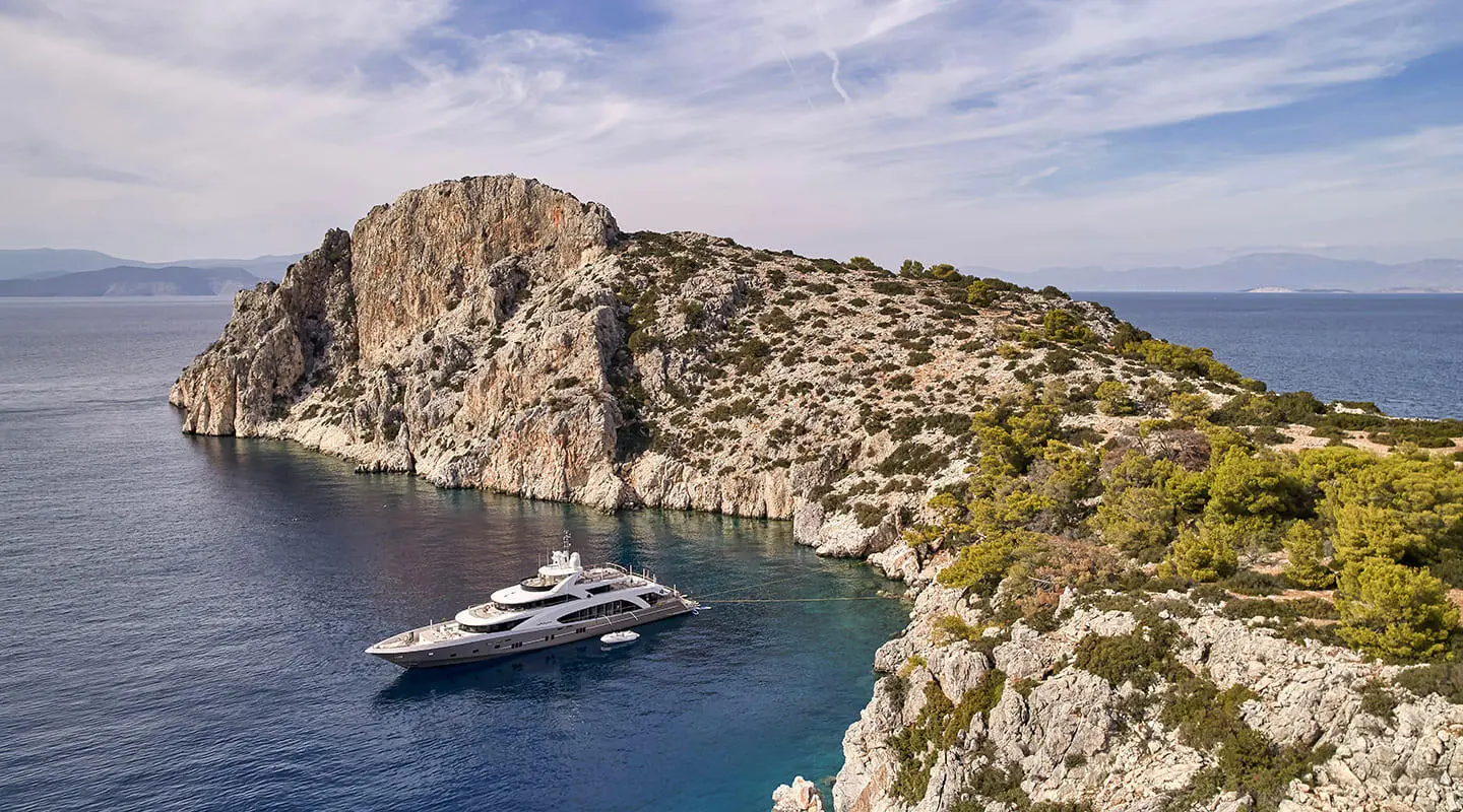 La Pellegrina 1 yacht anchored near rugged cliffs with clear blue water