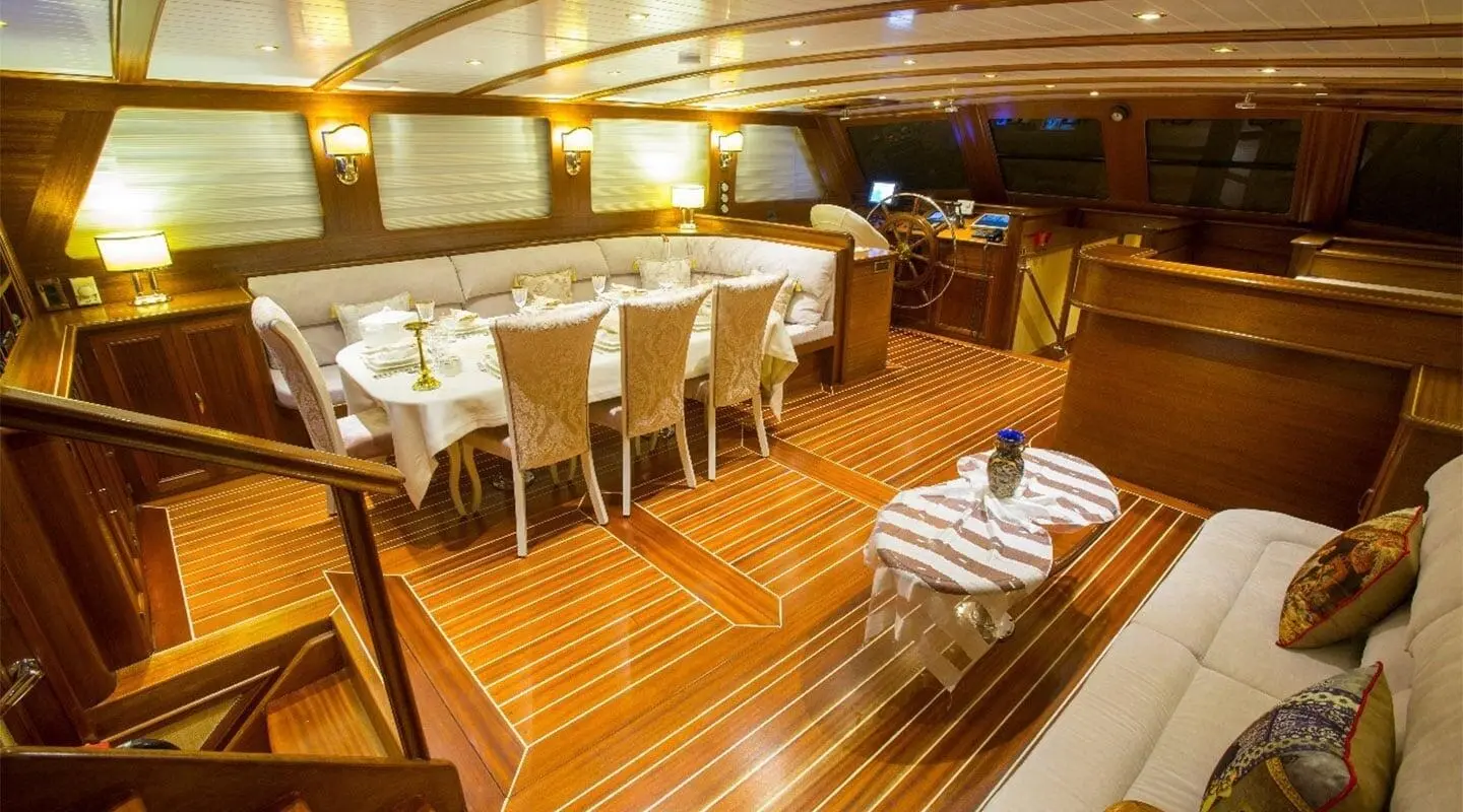 Interior of gulet Ece Berrak salon with wooden floor, seating and dining area