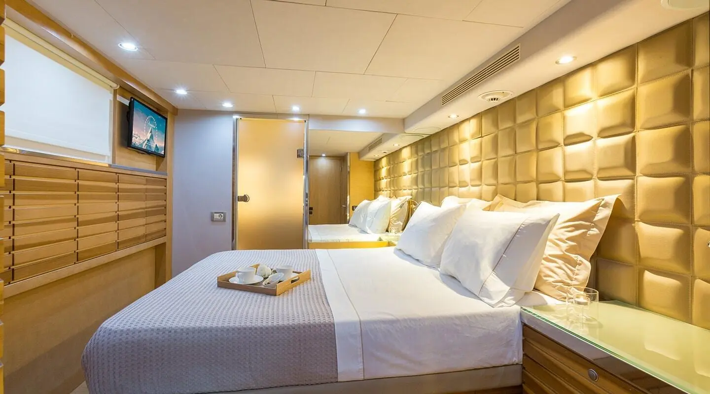 Aquarella motor yacht cabin with two large beds and warm lighting