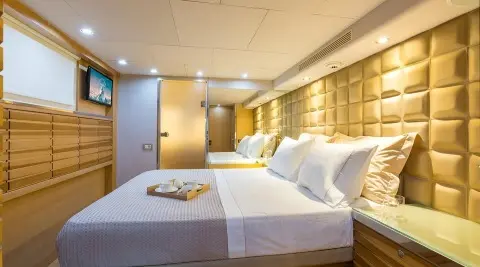 Aquarella motor yacht cabin with two large beds and warm lighting