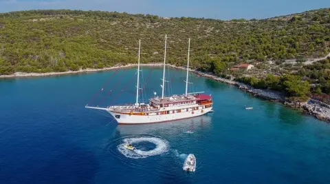 Amorena motor yacht seen from above, red and white vessel anchored in blue water