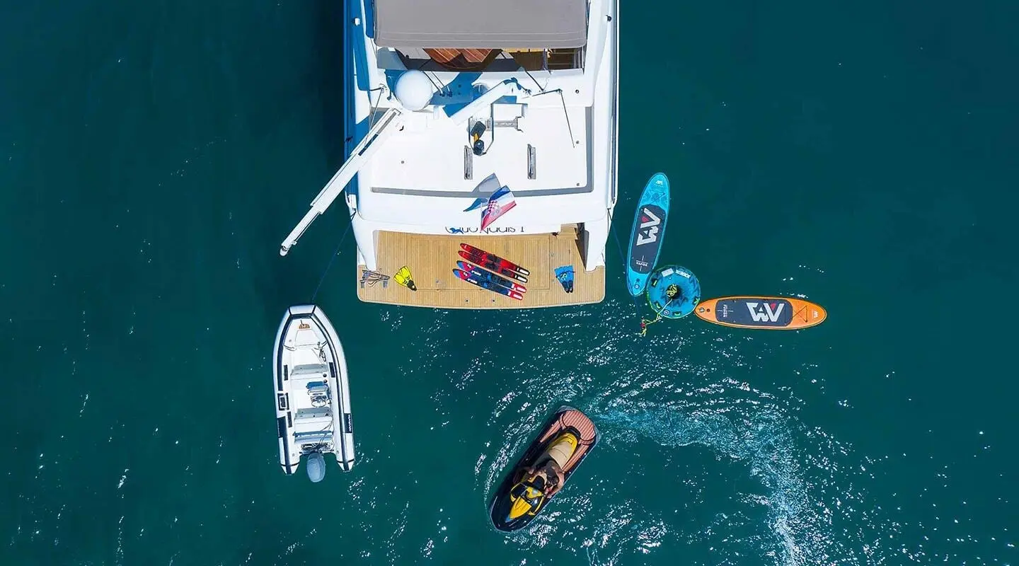 Aerial view of Quo Vadis I yacht anchored with dinghies nearby in clear blue water