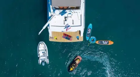 Aerial view of Quo Vadis I yacht anchored with dinghies nearby in clear blue water