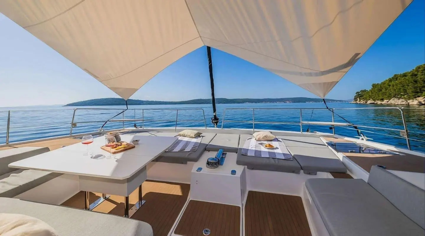Ocean Lounge yacht: shaded deck seating with tables and blue sea view