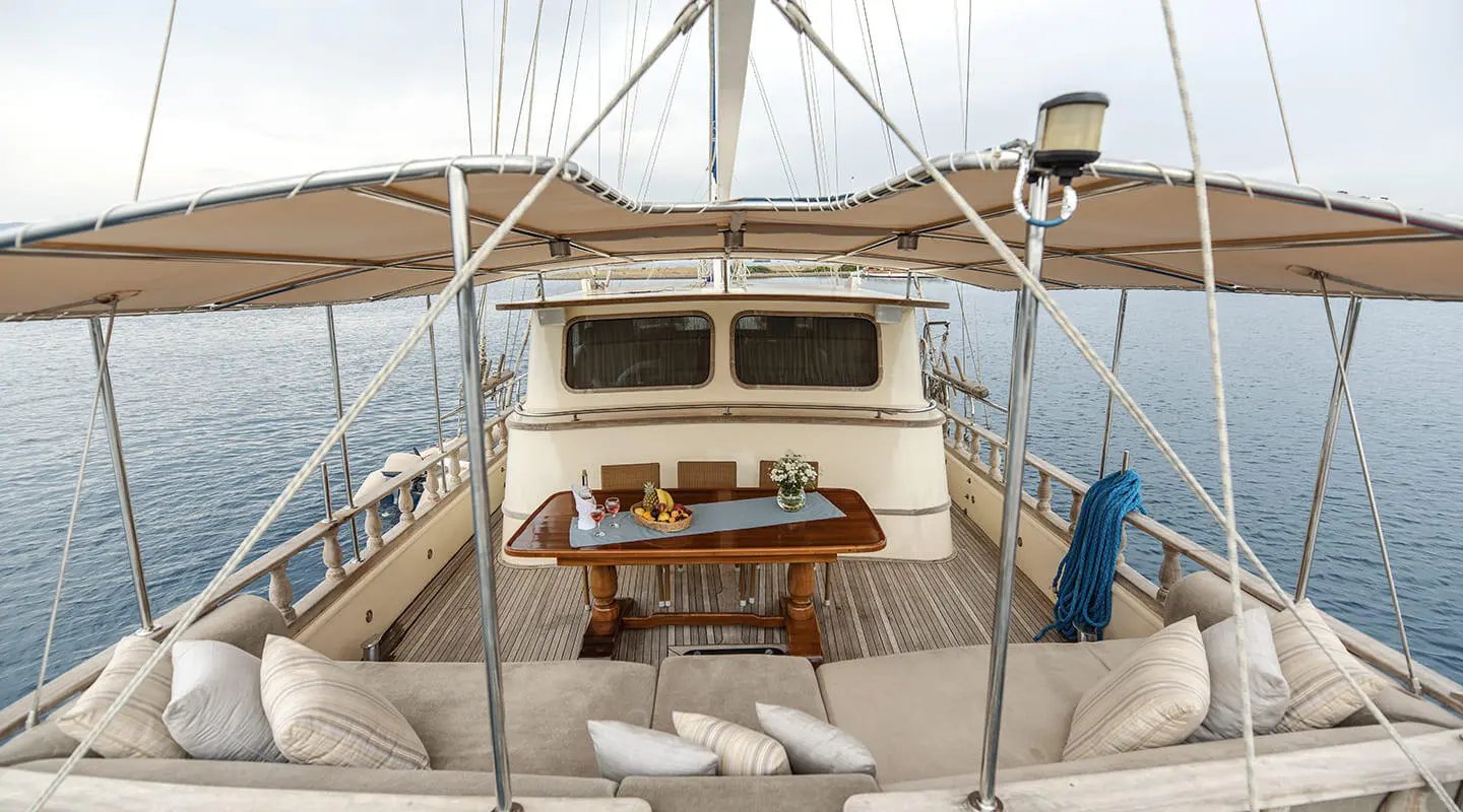 Faralya yacht deck view with seating area and helm, sunset sailing vibe