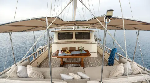 Faralya yacht deck view with seating area and helm, sunset sailing vibe