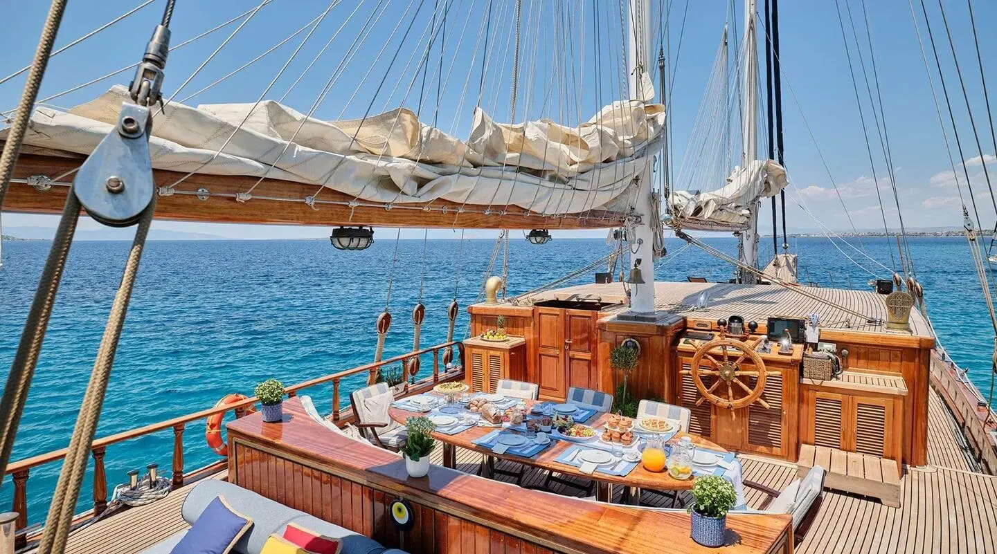 Gulet Myra aft deck with shaded awning, wooden seating, and turquoise sea view
