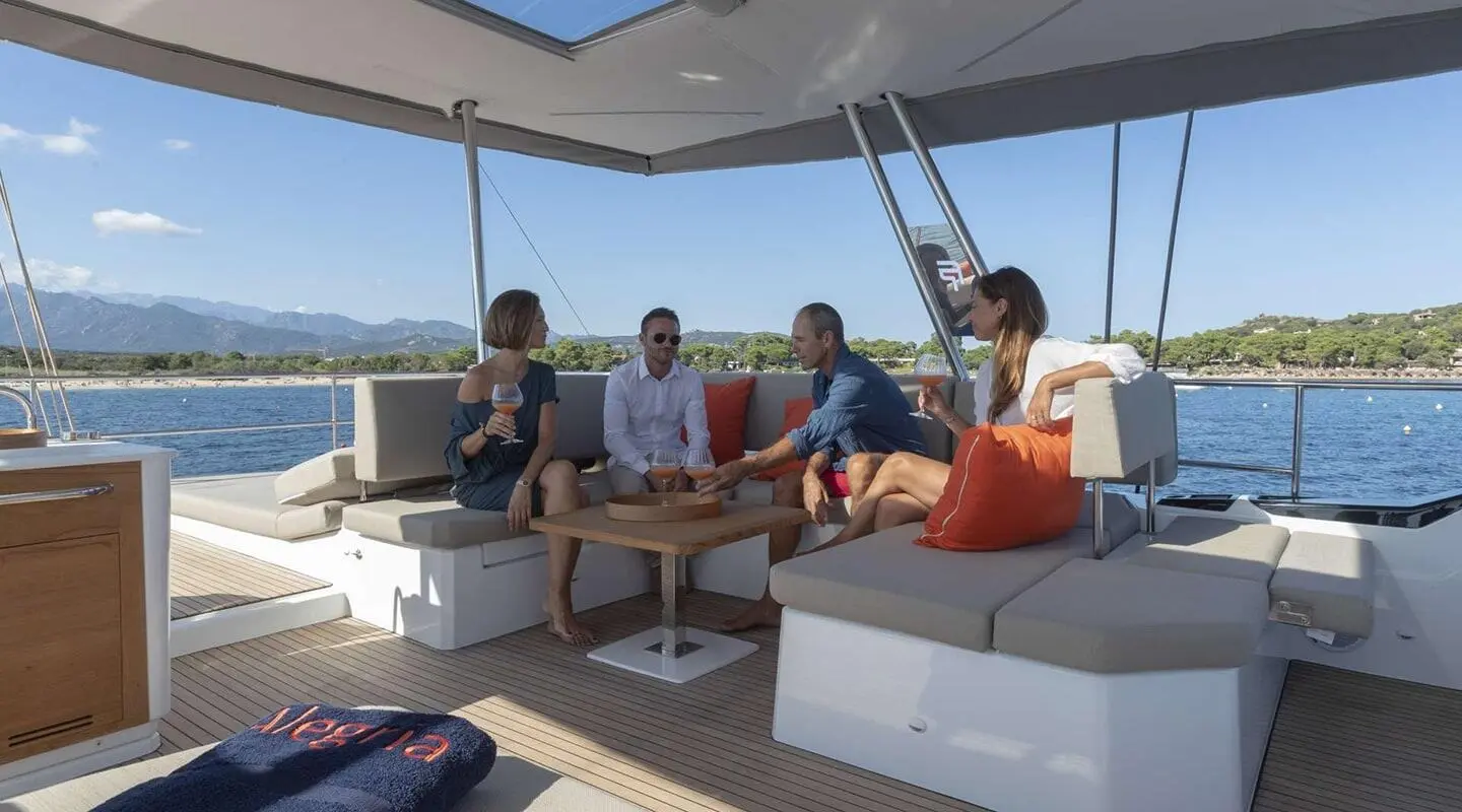 Open aft deck with sea view and people chatting on a seating area