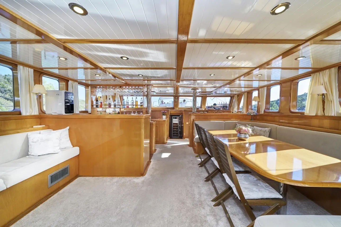 Interior of Morning Star gulet with wooden tables, chairs, and bright saloon