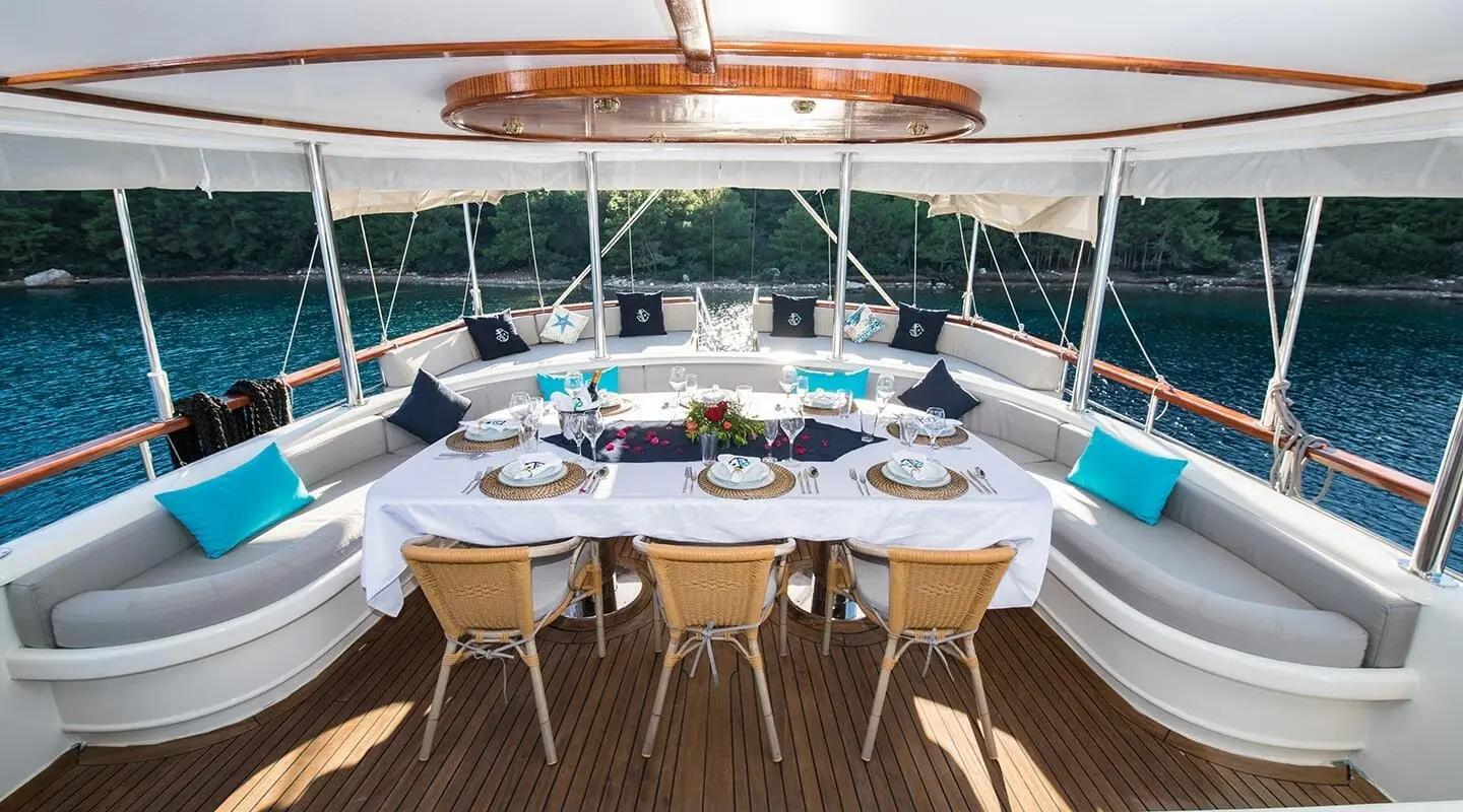 Vista Mare yacht deck seating area with table and chairs facing open sea at sunset