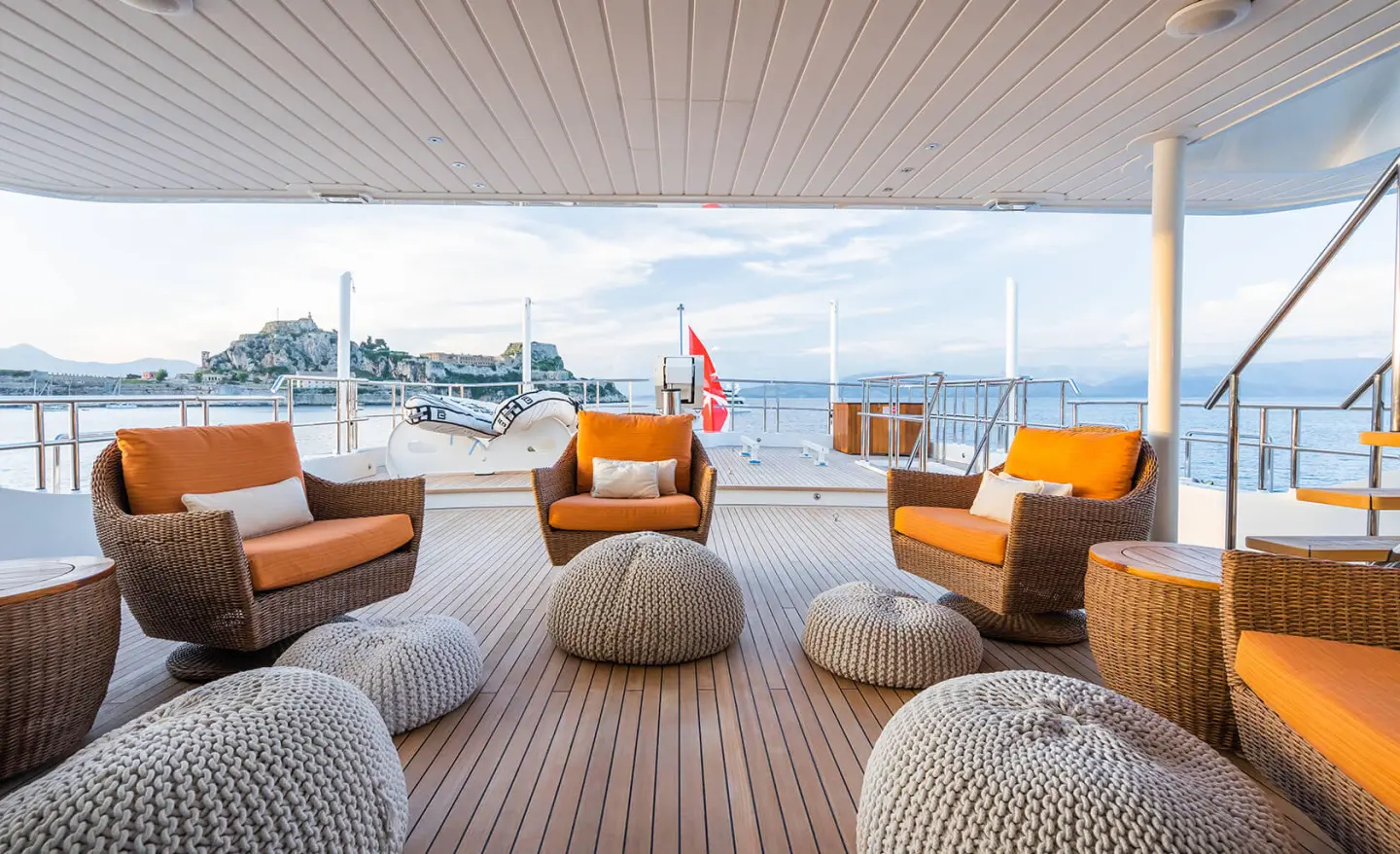 Serenity yacht deck seating area with orange cushions under sunset light