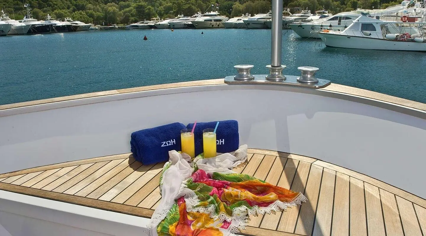 View from deck of Zoi yacht showing table with food and beverages on sunny harbor