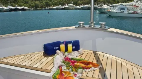 View from deck of Zoi yacht showing table with food and beverages on sunny harbor