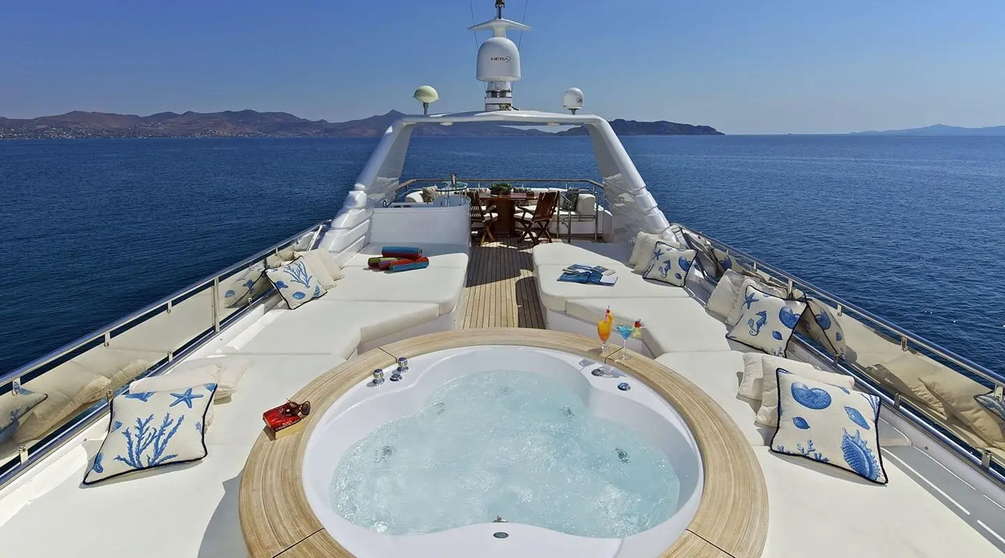 O'Rion luxury yacht deck at sunset with hot tub, seating, and railing