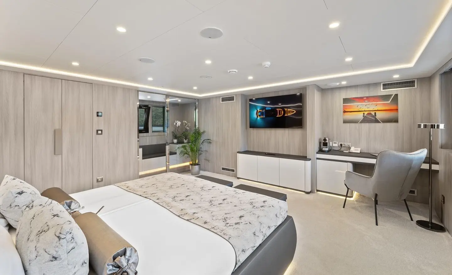 Interior of a luxury yacht cabin with a large bed and built-in seating area