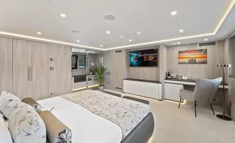 Interior of a luxury yacht cabin with a large bed and built-in seating area