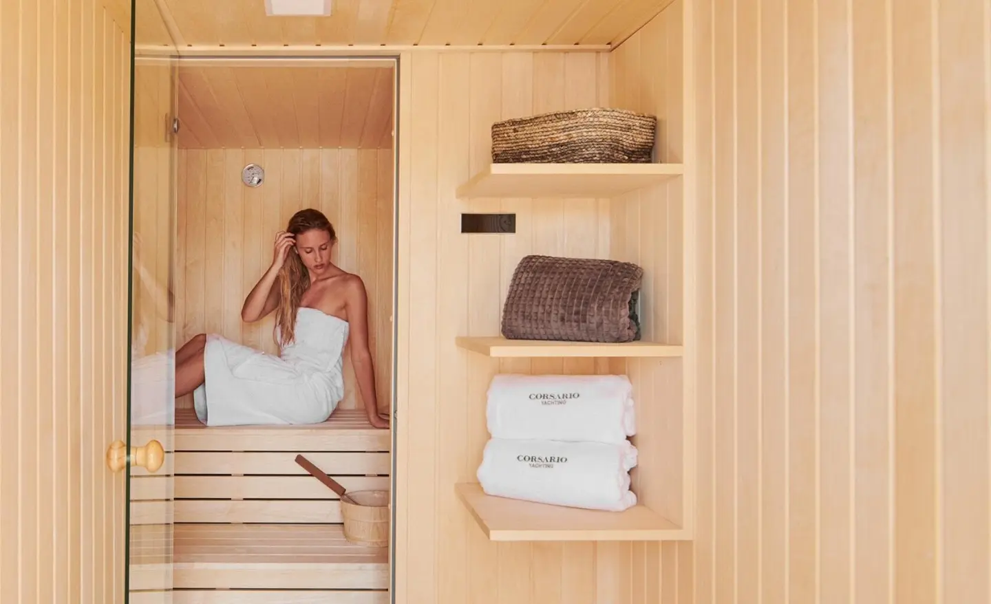Corsario luxury yacht spa sauna interior with a woman in a towel seated on the bench