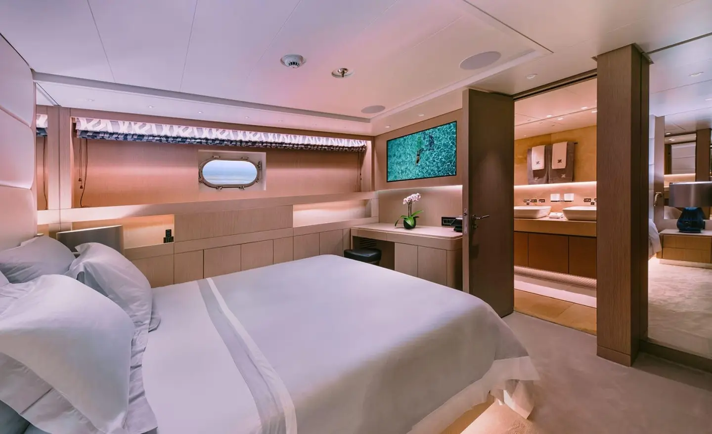 Interior of Xana yacht hotel-style bedroom with bed, seating, and warm lighting
