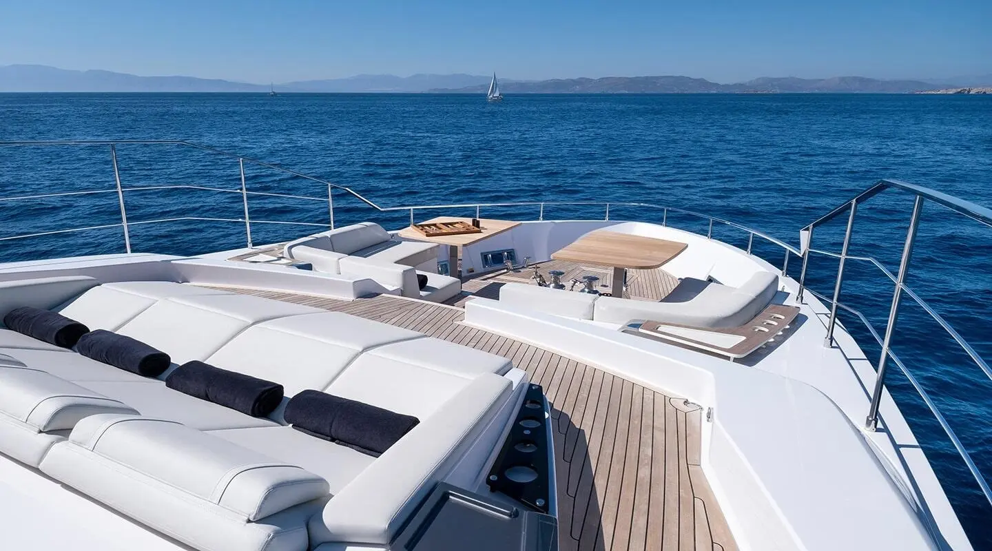 Spica luxury yacht deck with white seating and teak flooring overlooking the blue sea