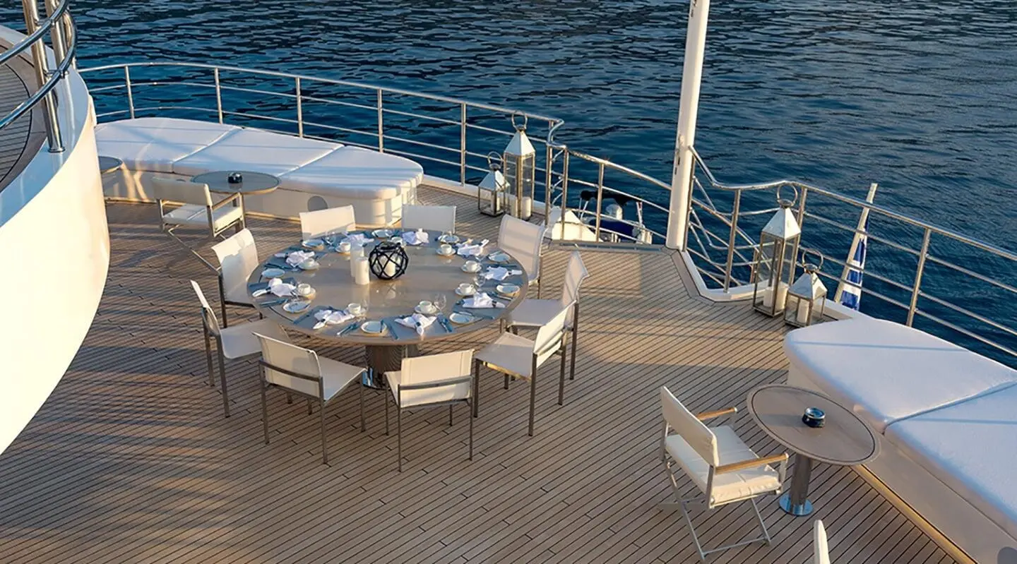 On deck with a large round table, white cushioned chairs and open sea view