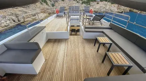 Maske 5 yacht deck with seating, teak floor, and sunset glow