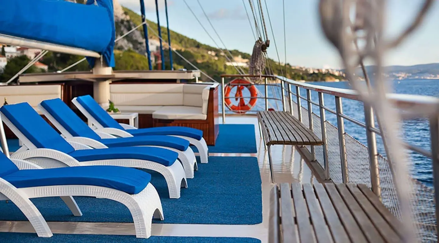 On deck, white sun loungers with blue cushions
