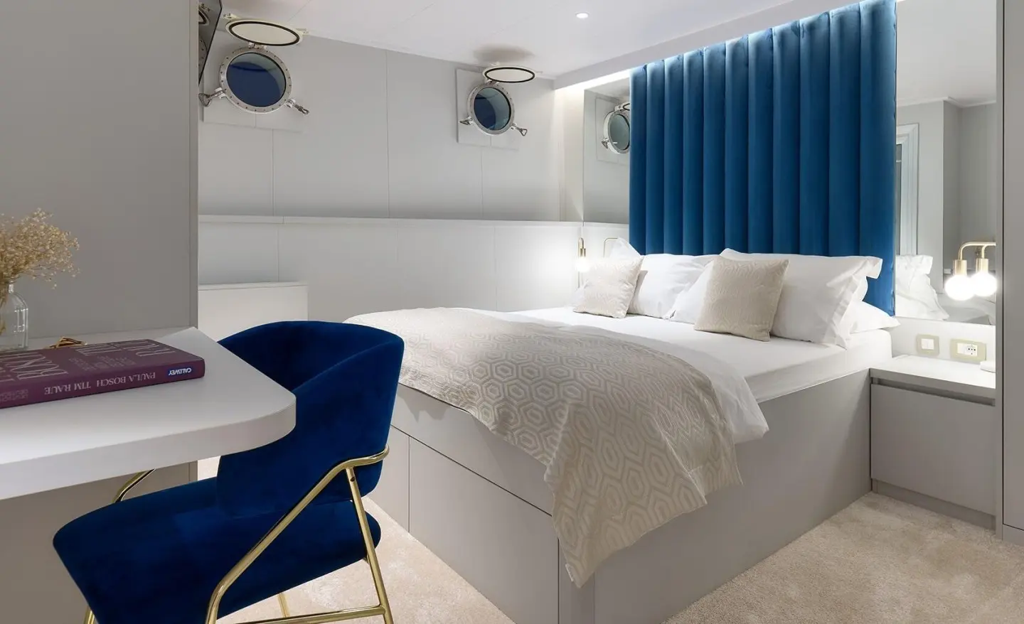Bellezza motor yacht interior with two white beds and blue accents