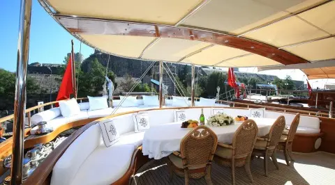 Luxurious sailing yacht Kaya Guneri 5 on calm waters with shaded seating under canopy