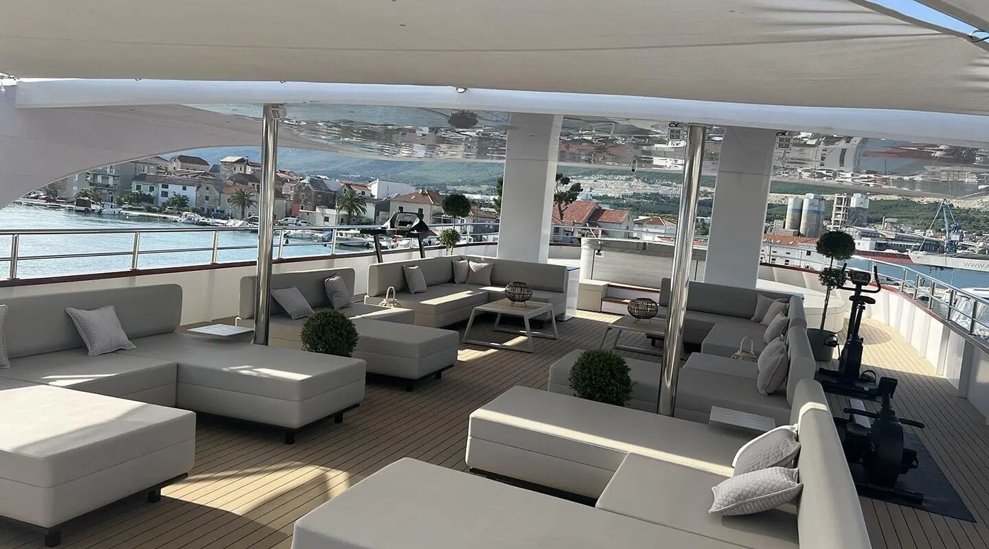 Melody motor yacht sun deck; white lounge seating and shaded area