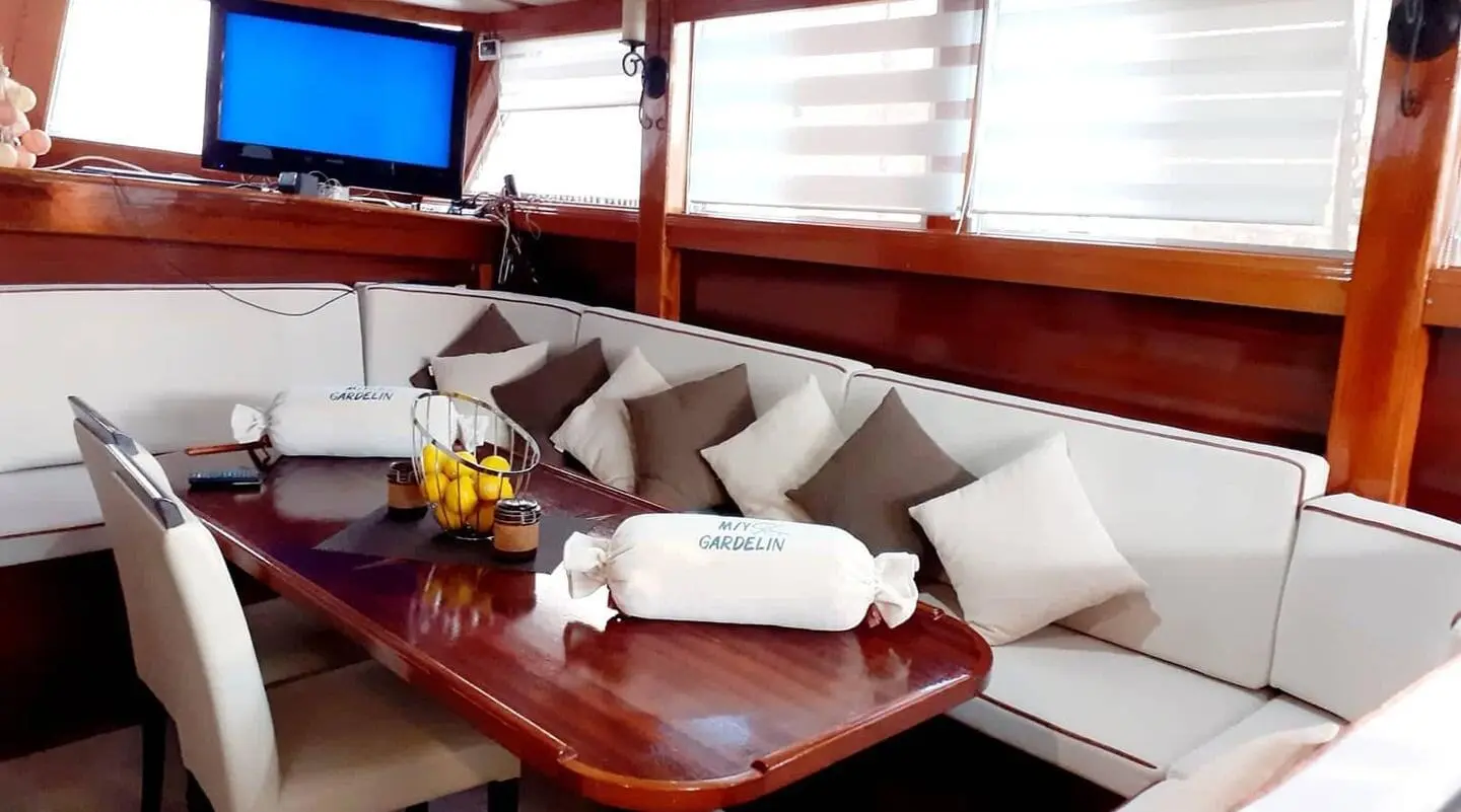 Gardelin yacht deck seating area with cushions and wooden table, sunset light