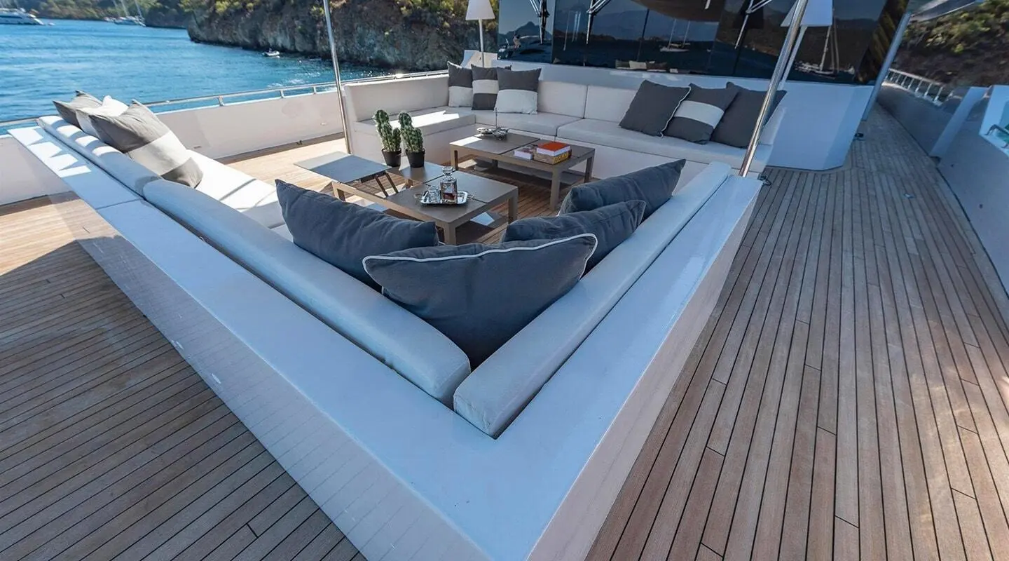 Ocean Breeze yacht deck seating area with cabinets and sunset glow on water