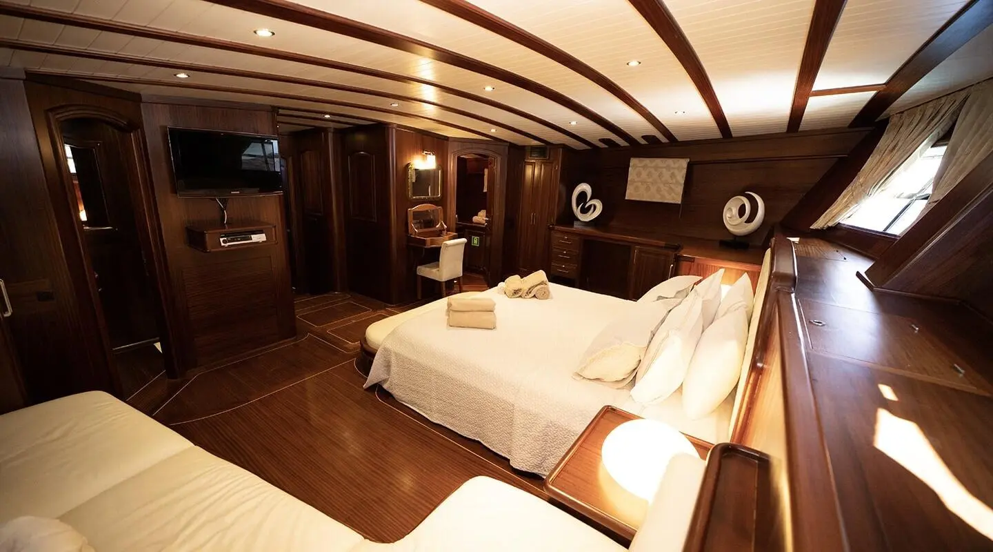 Arif Kaptan A interior yacht cabin with two single beds and warm lighting