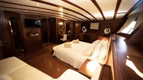 Arif Kaptan A interior yacht cabin with two single beds and warm lighting