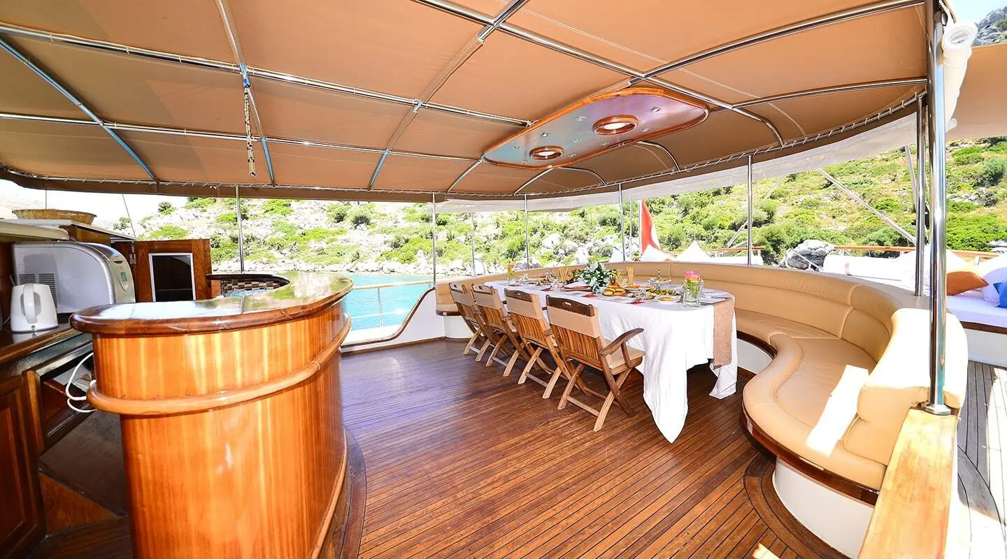 Prenses Bugce yacht charter: covered outdoor deck with long table and chairs