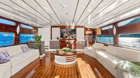 Esma Sultan yacht deck with polished wood, white seating, and open cockpit at sunset