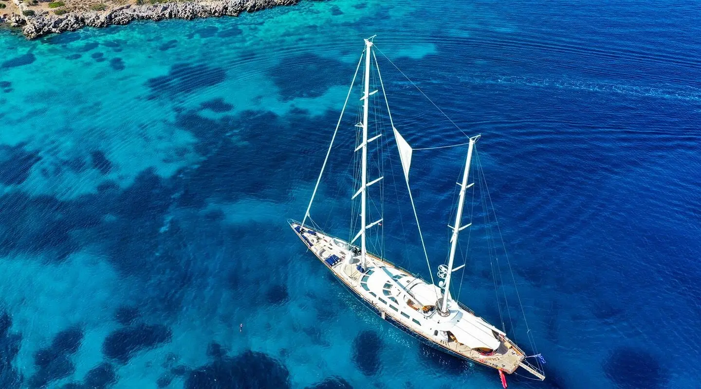 Aerial view of Tamarita sailing yacht anchored in turquoise blue water