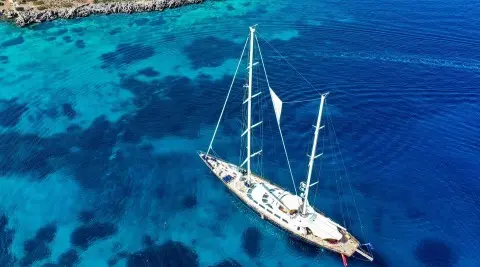 Aerial view of Tamarita sailing yacht anchored in turquoise blue water