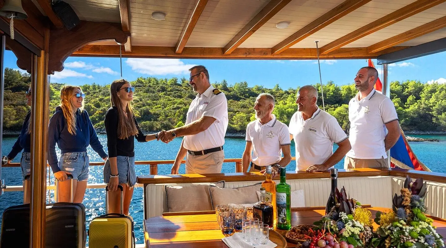 Aborda yacht charter scene on deck with people chatting at sunset, luxury seating