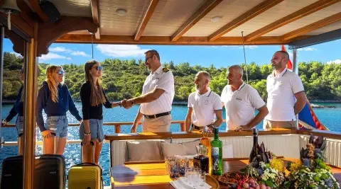 Aborda yacht charter scene on deck with people chatting at sunset, luxury seating
