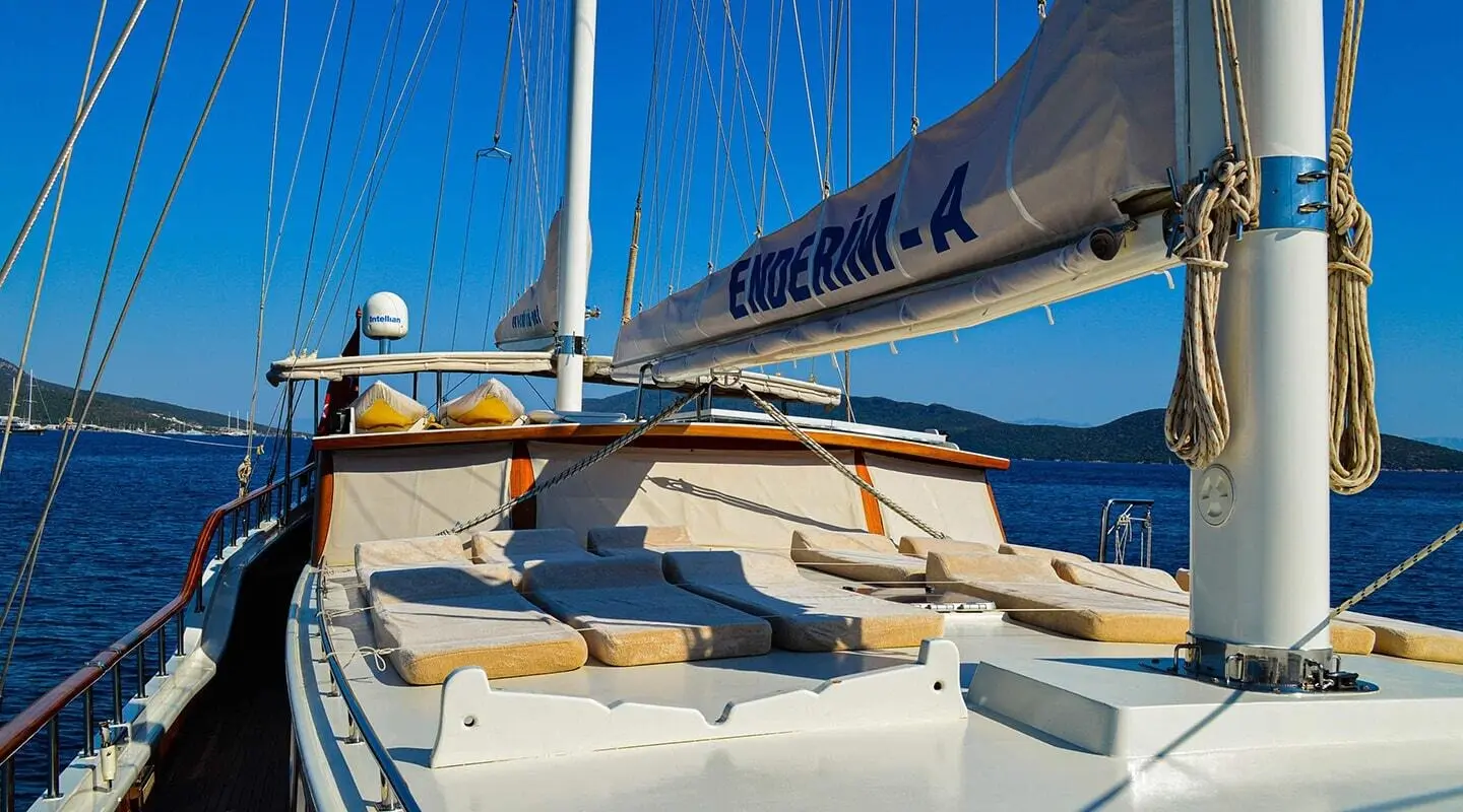 Deck view of the gulet Enderim A with blue sails and white seating