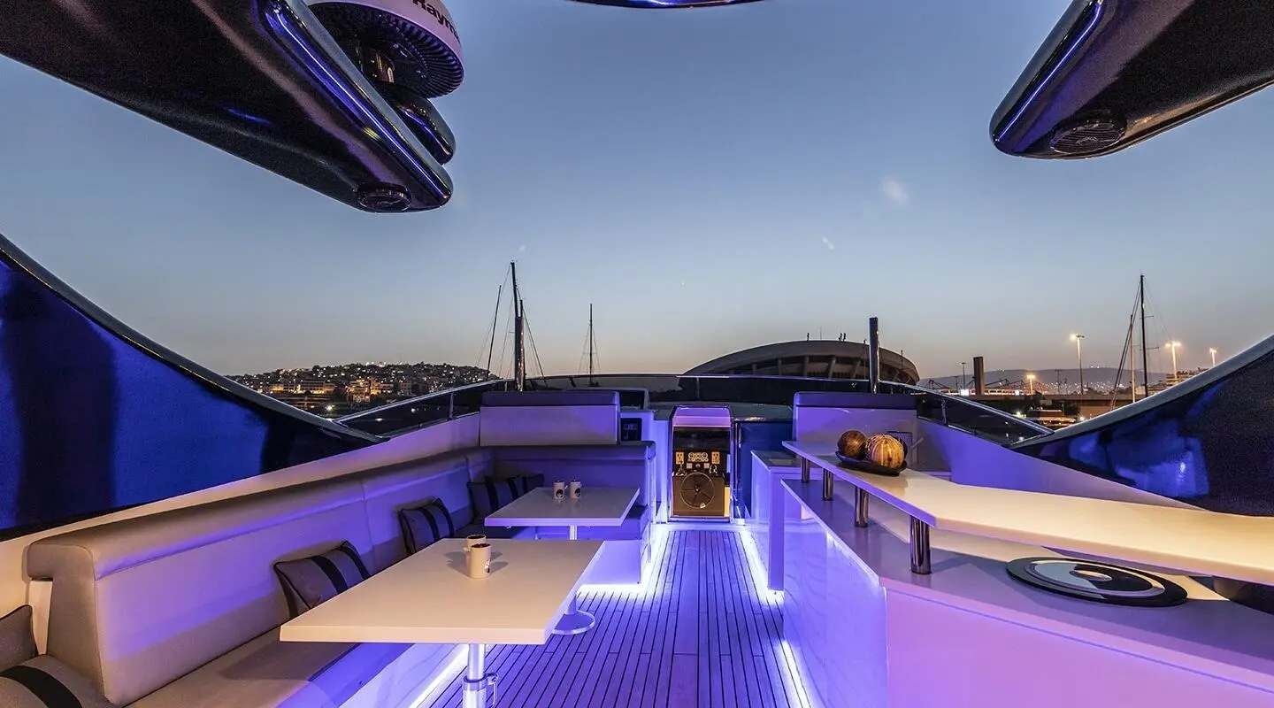Project Steel motor yacht at night with illuminated deck and seating on flybridge