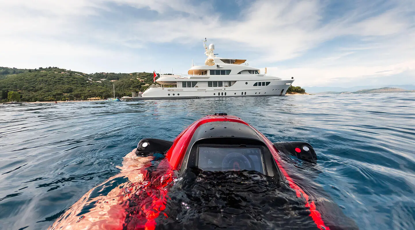 Serenity yacht seen from water with red kayak in foreground and calm sea