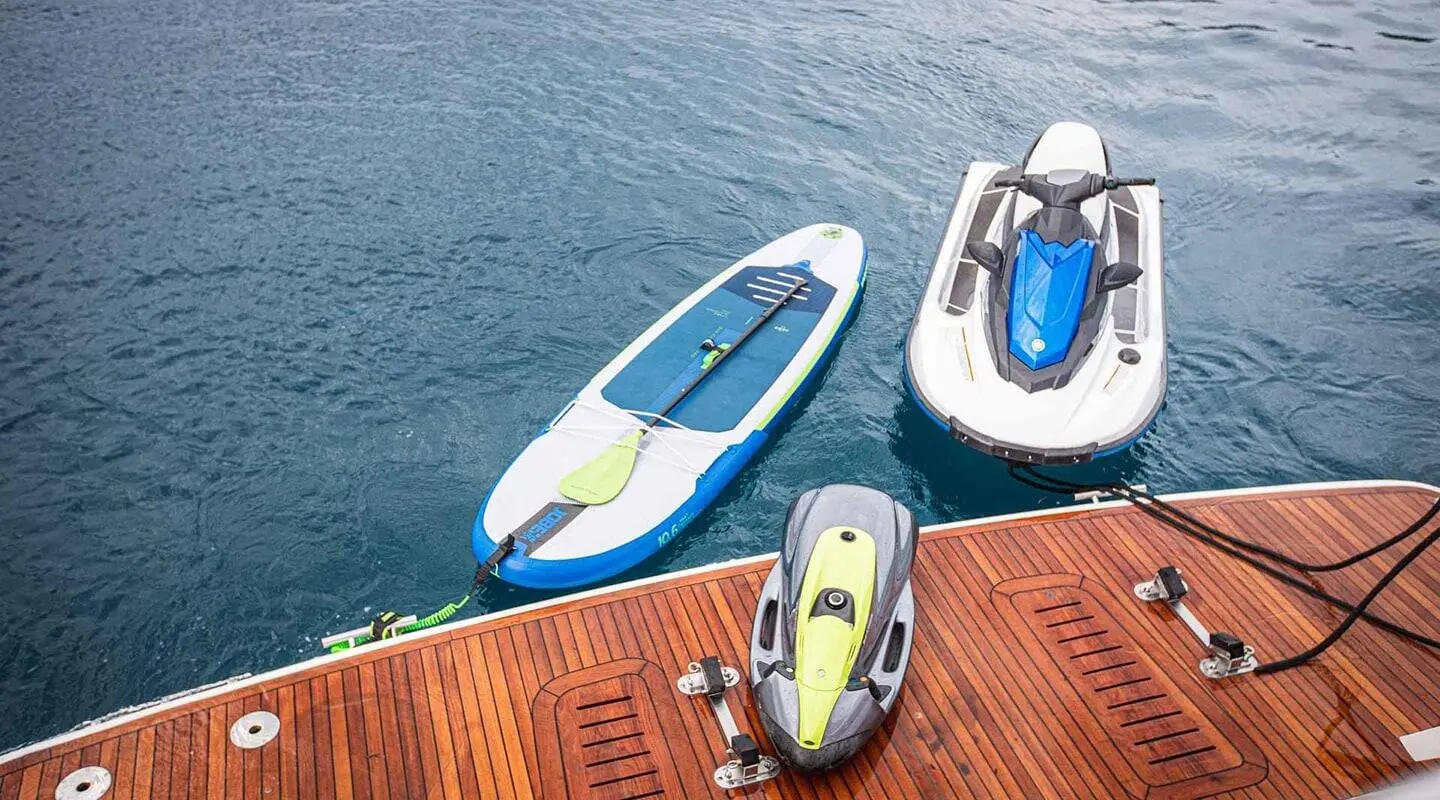 Insieme yacht deck with water toys: jet ski and stand-up paddleboard tied to the stern