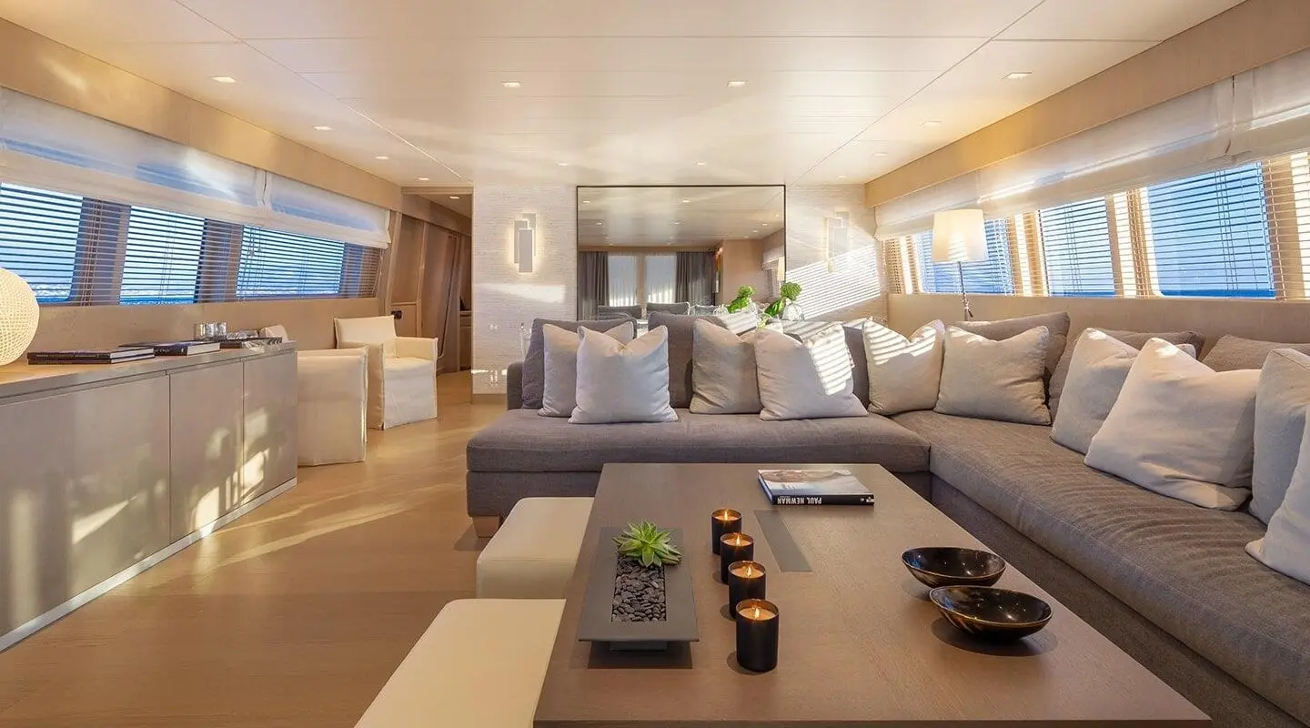 Luxurious yacht living area with sofa seating, coffee table, and windows